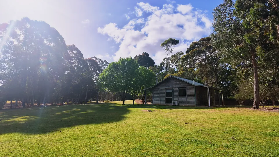 Log cabin on the lawn under a big sky